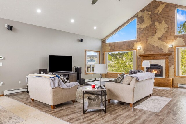 207 Cyprus Dr, Butte, MT 59701 - living room featuring high vaulted ceiling, baseboard heating, a fireplace, a baseboard radiator, and wood finished floors