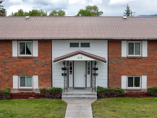 218 W Nevada St # 1 2 3 4, Kalispell, MT 59901 - view of front of property featuring a front lawn, metal roof, and brick siding