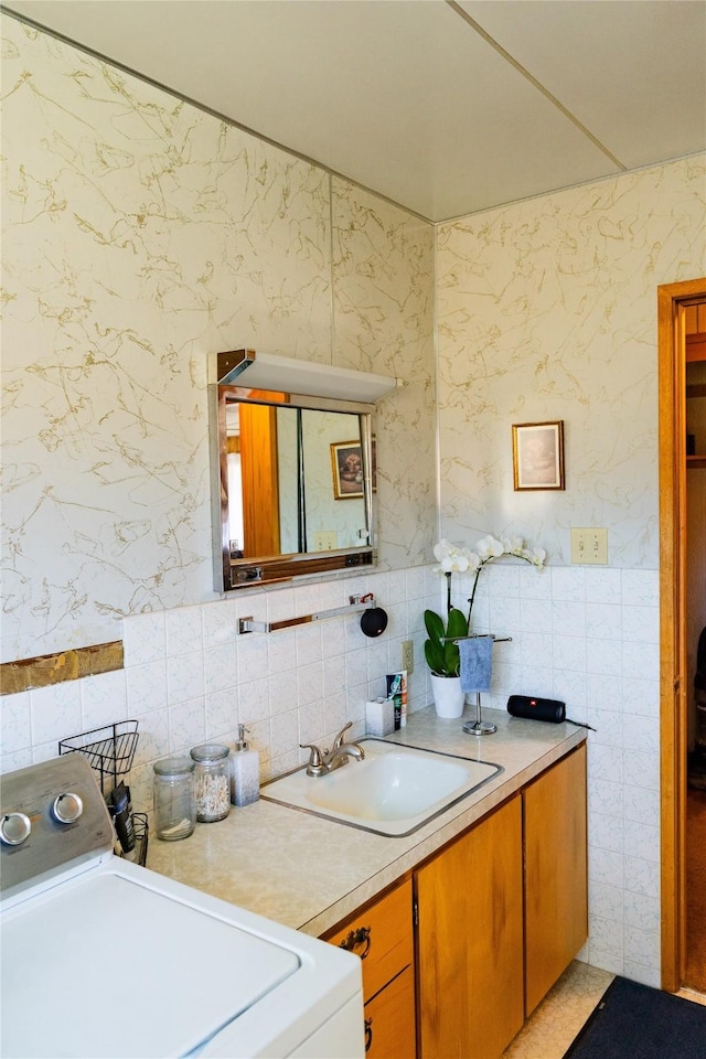 1807 1st St E, Polson, MT 59860 - bathroom with washer / clothes dryer, tile walls, vanity, and tasteful backsplash