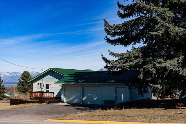 1807 1st St E, Polson, MT 59860 - view of home's exterior with a garage, a mountain view, and a metal roof
