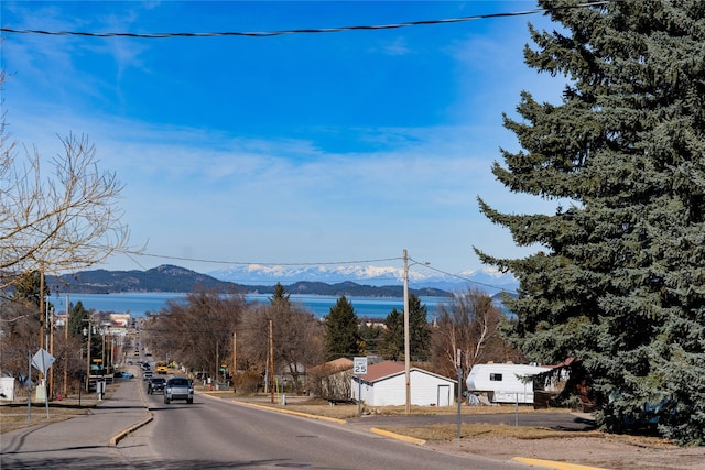 1807 1st St E, Polson, MT 59860 - view of asphalt road with a mountain view, curbs, traffic signs, and sidewalks