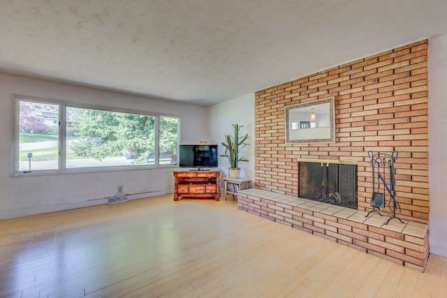 2046 Fairway Dr, Billings, MT 59102 - living area with wood finished floors, a brick fireplace, and a textured ceiling