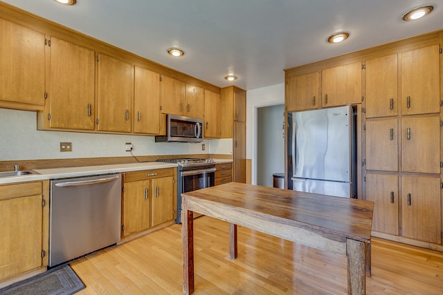 2046 Fairway Dr, Billings, MT 59102 - kitchen with stainless steel appliances, light wood-style floors, light countertops, and brown cabinets