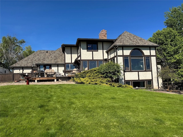 215 Somerset Dr, Kalispell, MT 59901 - rear view of property with a chimney, stucco siding, a yard, and a deck