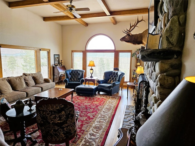 215 Somerset Dr, Kalispell, MT 59901 - living room featuring wood finished floors, a stone fireplace, beam ceiling, coffered ceiling, and a ceiling fan