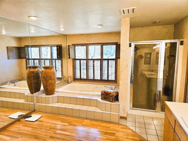 215 Somerset Dr, Kalispell, MT 59901 - full bath with a textured ceiling, a stall shower, a garden tub, wood finished floors, and vanity