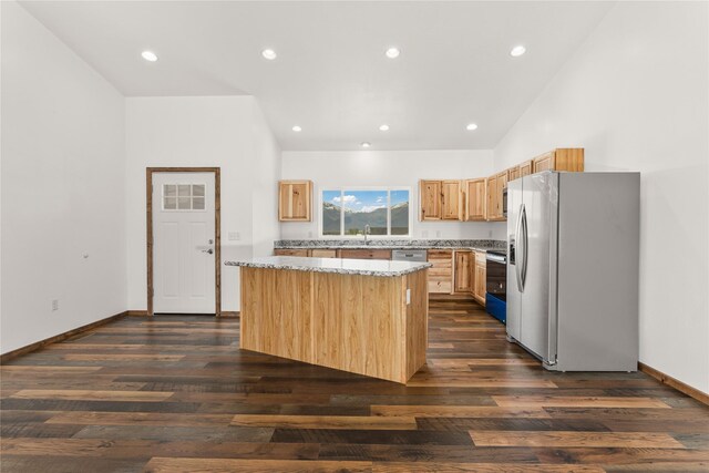 4452 Ludwig Ln, Stevensville, MT 59870 - kitchen featuring stainless steel appliances, light brown cabinetry, vaulted ceiling, a kitchen island, and a sink