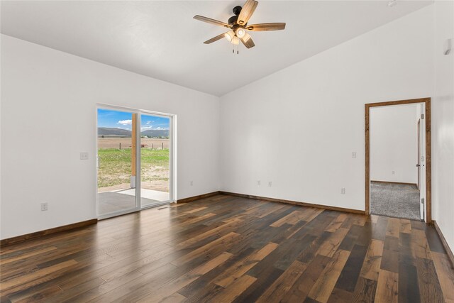 4452 Ludwig Ln, Stevensville, MT 59870 - spare room with dark wood-style floors, a ceiling fan, vaulted ceiling, and baseboards