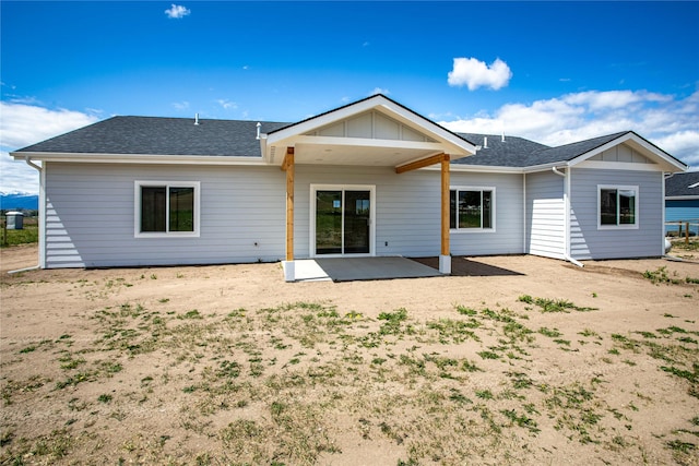 4452 Ludwig Ln, Stevensville, MT 59870 - back of property with board and batten siding, roof with shingles, and a patio