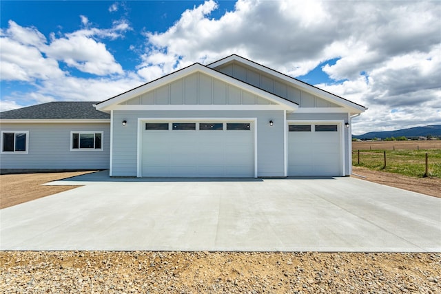 4452 Ludwig Ln, Stevensville, MT 59870 - view of front of property featuring an attached garage, concrete driveway, board and batten siding, and a mountain view