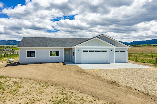 4452 Ludwig Ln, Stevensville, MT 59870 - ranch-style home featuring dirt driveway, a mountain view, a garage, and board and batten siding