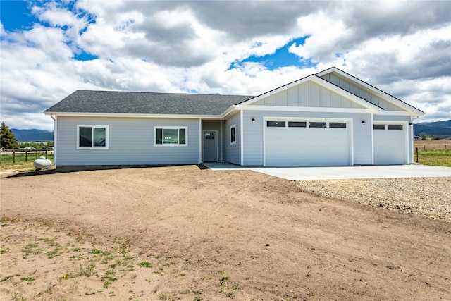 4452 Ludwig Ln, Stevensville, MT 59870 - single story home with concrete driveway, an attached garage, a shingled roof, and board and batten siding