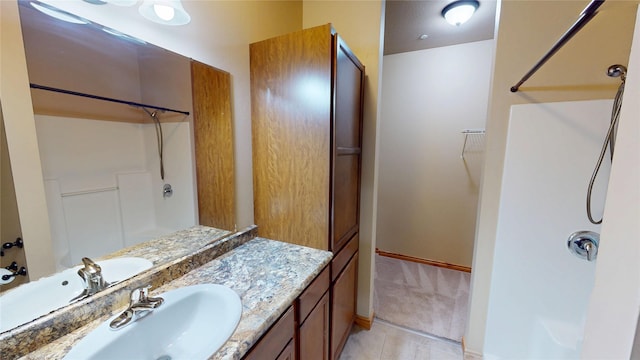 4100 Mullan Rd Unit 712, Missoula, MT 59808 - bathroom featuring a shower, vanity, tile patterned flooring, and baseboards