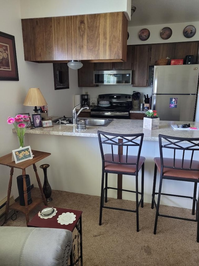 1345 S 2nd St W, Missoula, MT 59801 - kitchen featuring stainless steel appliances, a kitchen breakfast bar, light countertops, and a sink