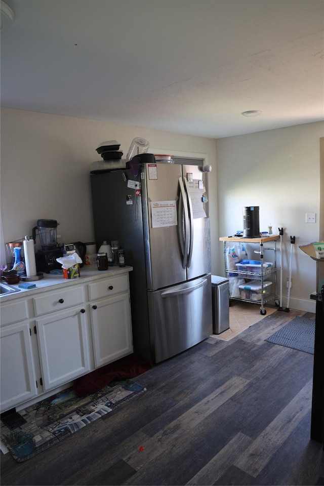 507 2nd St, Valier, MT 59486 - kitchen with freestanding refrigerator, wood finished floors, white cabinetry, and light countertops