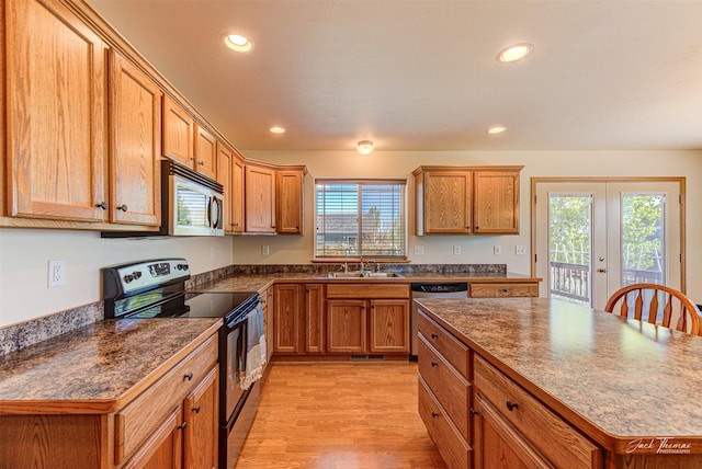 kitchen with stainless steel appliances, a sink, dark countertops, french doors, and recessed lighting