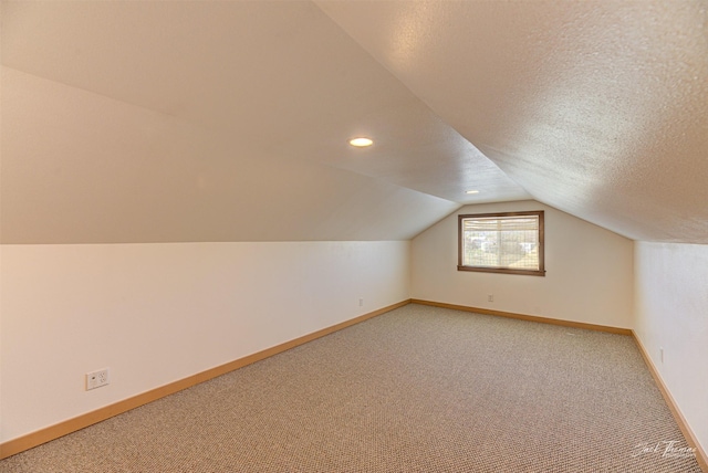bonus room with light carpet, baseboards, vaulted ceiling, a textured ceiling, and recessed lighting