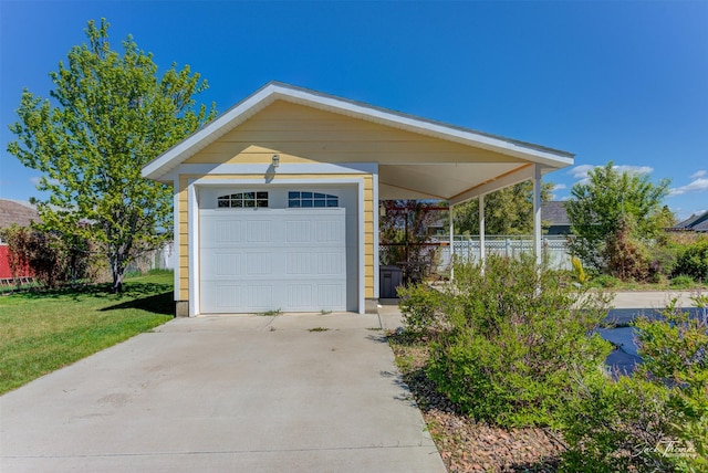 garage with driveway and a detached garage