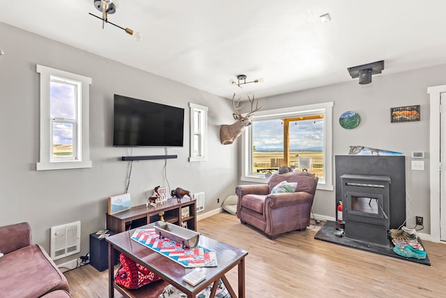 49 Embry Ln, Great Falls, MT 59404 - living area featuring heating unit, a wood stove, and light wood finished floors