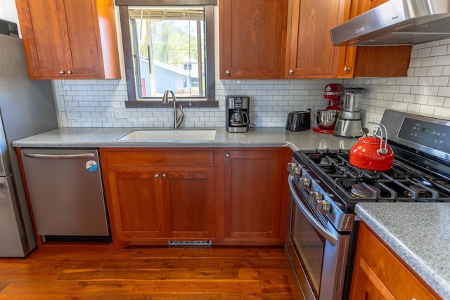 1827 Hollins Ave, Helena, MT 59601 - kitchen featuring stainless steel appliances, under cabinet range hood, a sink, dark wood-type flooring, and light countertops