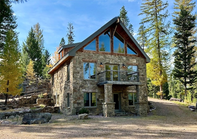 237 N Monture Ct, Seeley Lake, MT 59868 - rear view of property with stone siding and a balcony