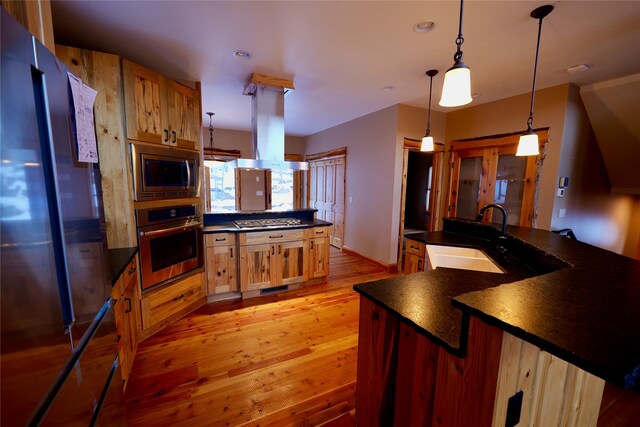 237 N Monture Ct, Seeley Lake, MT 59868 - kitchen featuring stainless steel appliances, dark countertops, a sink, light wood-type flooring, and recessed lighting