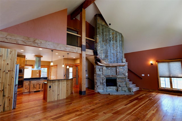 237 N Monture Ct, Seeley Lake, MT 59868 - unfurnished living room featuring healthy amount of natural light, light wood-style floors, high vaulted ceiling, beamed ceiling, and stairs