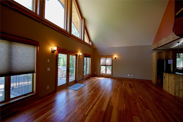 237 N Monture Ct, Seeley Lake, MT 59868 - unfurnished living room featuring high vaulted ceiling, hardwood / wood-style floors, and baseboards