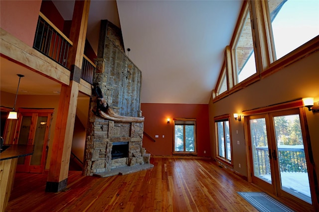 237 N Monture Ct, Seeley Lake, MT 59868 - unfurnished living room with a high ceiling, hardwood / wood-style flooring, a fireplace, french doors, and baseboards