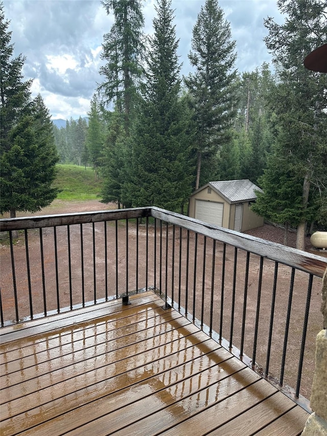 237 N Monture Ct, Seeley Lake, MT 59868 - deck featuring a detached garage and an outbuilding