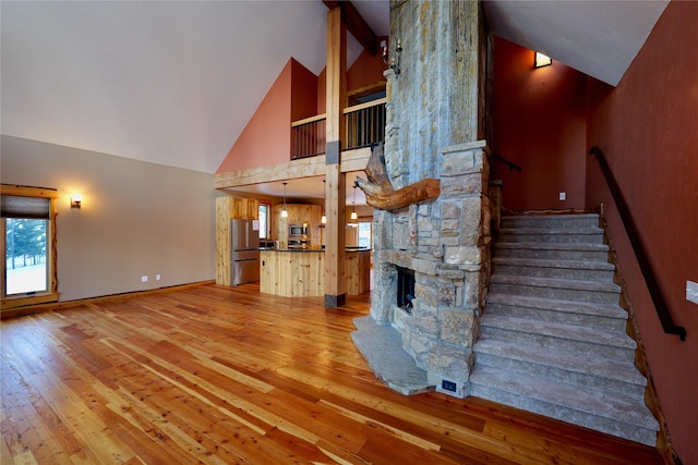 237 N Monture Ct, Seeley Lake, MT 59868 - staircase featuring high vaulted ceiling, wood-type flooring, healthy amount of natural light, baseboards, and beam ceiling