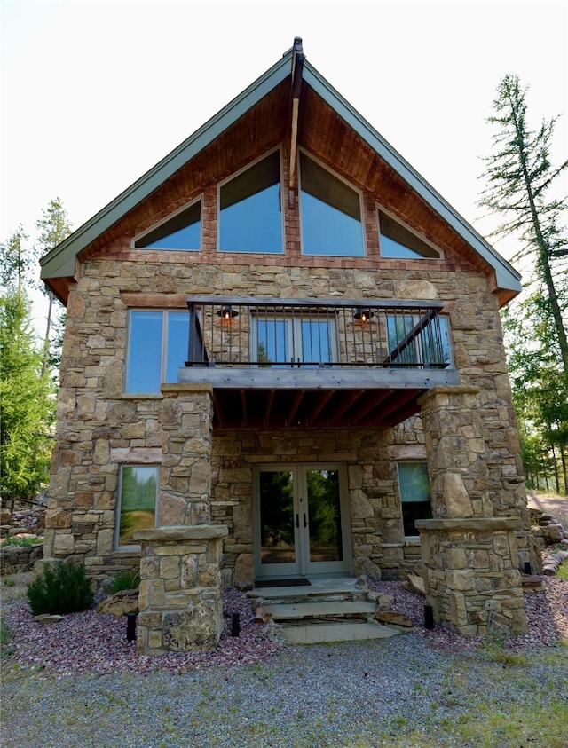 237 N Monture Ct, Seeley Lake, MT 59868 - rear view of property with french doors, a balcony, and stone siding