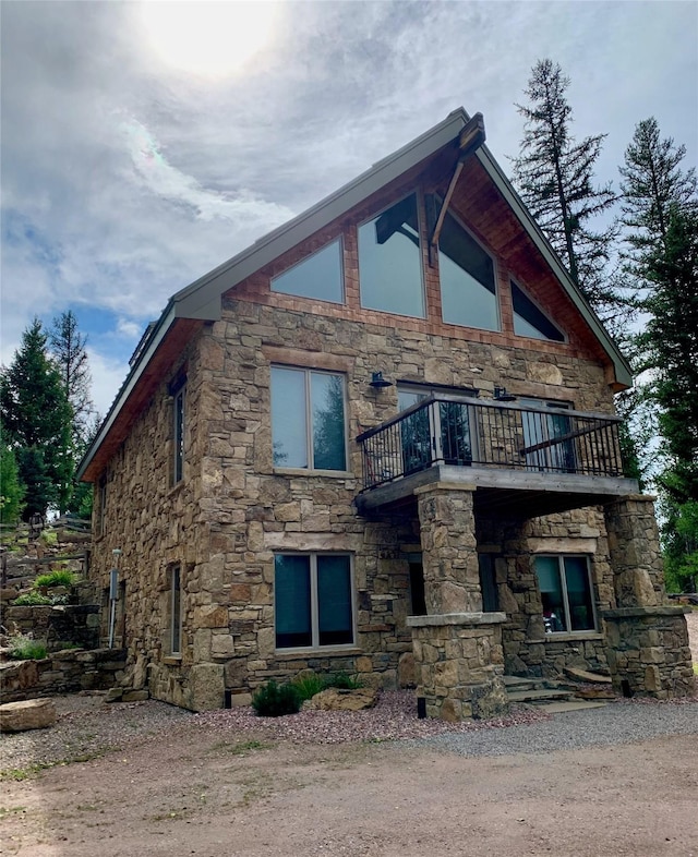 237 N Monture Ct, Seeley Lake, MT 59868 - view of property exterior featuring a balcony and stone siding