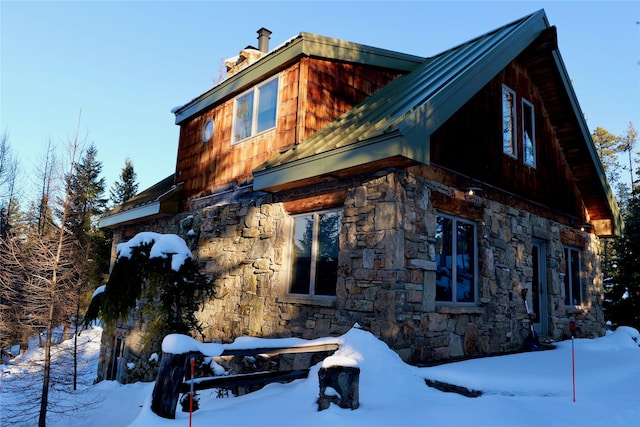 237 N Monture Ct, Seeley Lake, MT 59868 - snow covered property featuring stone siding and a chimney