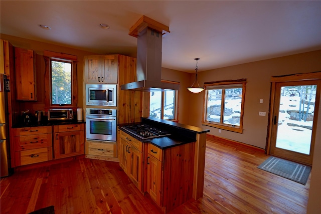 237 N Monture Ct, Seeley Lake, MT 59868 - kitchen featuring stainless steel appliances, brown cabinetry, hardwood / wood-style flooring, island range hood, and recessed lighting