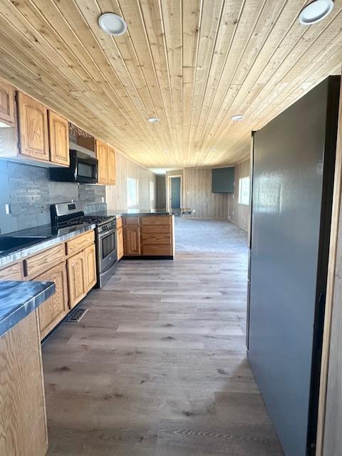2900 S Montana St Unit 14, Butte, MT 59701 - kitchen featuring stainless steel gas stove, wooden ceiling, a peninsula, wood finished floors, and healthy amount of natural light
