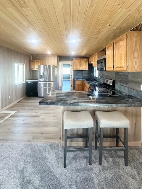 2900 S Montana St Unit 14, Butte, MT 59701 - kitchen featuring appliances with stainless steel finishes, wooden ceiling, a peninsula, dark countertops, and a sink
