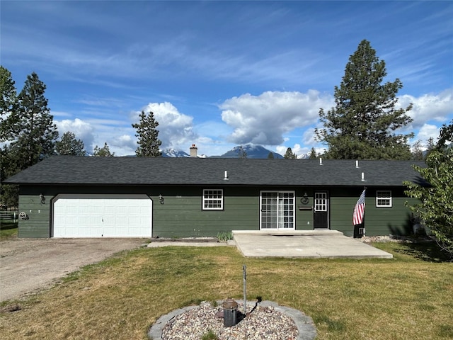 5061 Falcon Ln, Stevensville, MT 59870 - rear view of house with a lawn, an attached garage, dirt driveway, and a patio area