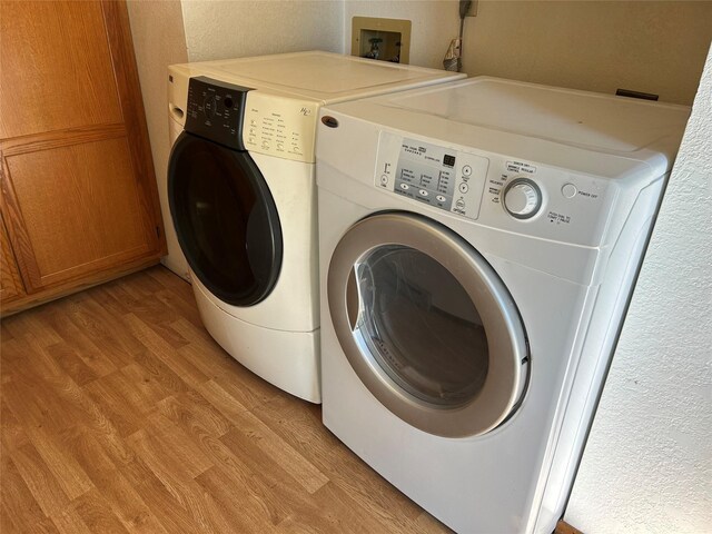 5061 Falcon Ln, Stevensville, MT 59870 - washroom featuring washer and clothes dryer, light wood finished floors, and a textured wall