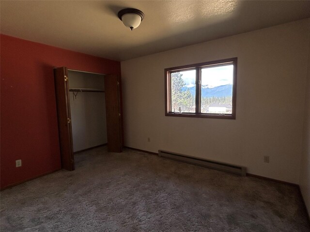 5061 Falcon Ln, Stevensville, MT 59870 - unfurnished bedroom featuring a baseboard radiator, carpet flooring, a closet, and baseboards