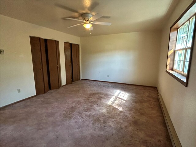 5061 Falcon Ln, Stevensville, MT 59870 - unfurnished bedroom with two closets, a baseboard radiator, carpet, and a ceiling fan