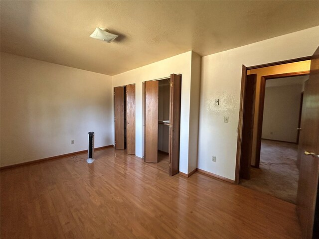 5061 Falcon Ln, Stevensville, MT 59870 - unfurnished bedroom with multiple closets, wood finished floors, and baseboards