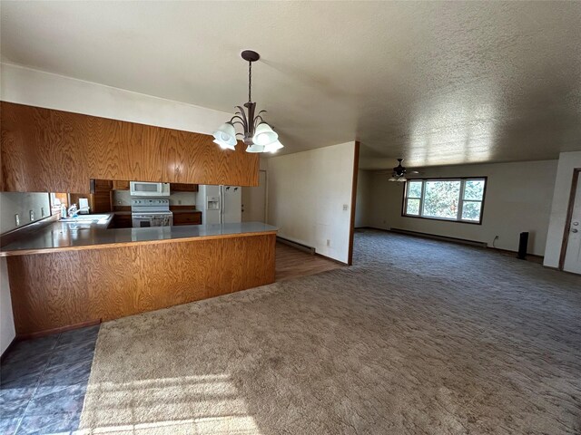 5061 Falcon Ln, Stevensville, MT 59870 - kitchen featuring white appliances, a sink, a peninsula, brown cabinetry, and a chandelier