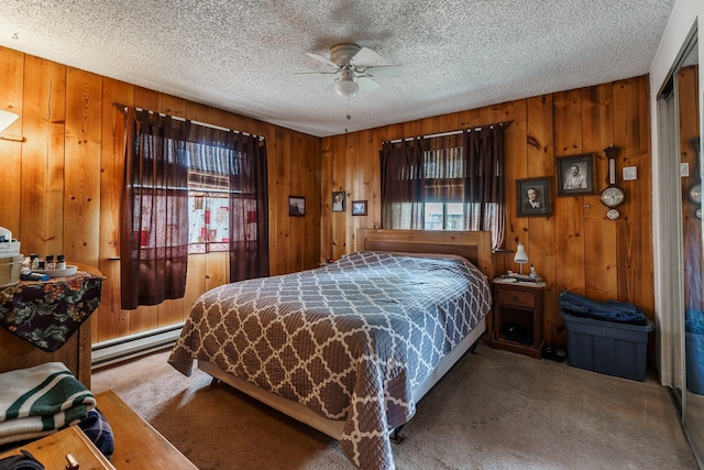 521 Clay St, Thompson Falls, MT 59873 - bedroom with carpet floors, baseboard heating, wood walls, a textured ceiling, and a ceiling fan