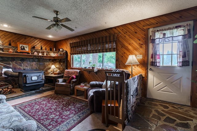 521 Clay St, Thompson Falls, MT 59873 - living room with a wood stove, a textured ceiling, a ceiling fan, wood walls, and recessed lighting
