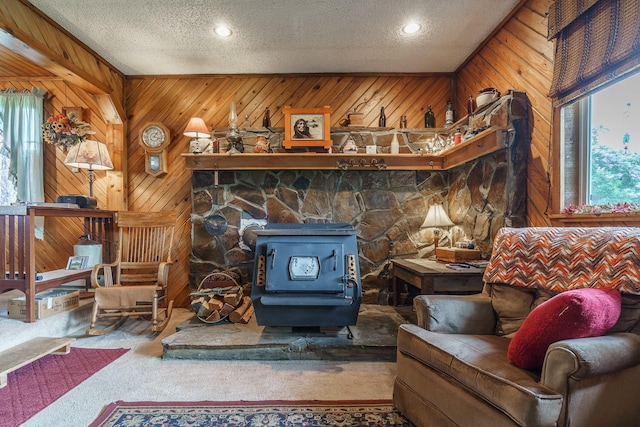 521 Clay St, Thompson Falls, MT 59873 - carpeted living room featuring a wood stove, plenty of natural light, a textured ceiling, wood walls, and recessed lighting
