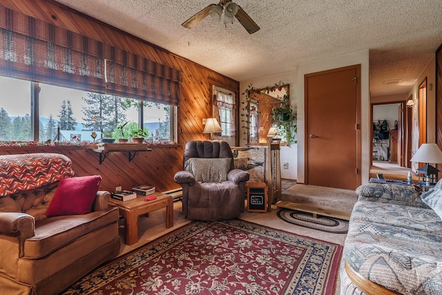 521 Clay St, Thompson Falls, MT 59873 - living area with wooden walls, ceiling fan, carpet floors, a textured ceiling, and a baseboard radiator