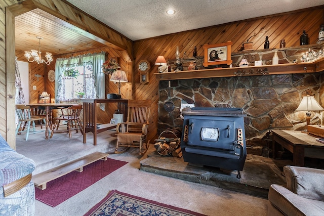 521 Clay St, Thompson Falls, MT 59873 - living room with a wood stove, carpet flooring, a chandelier, wood walls, and a textured ceiling