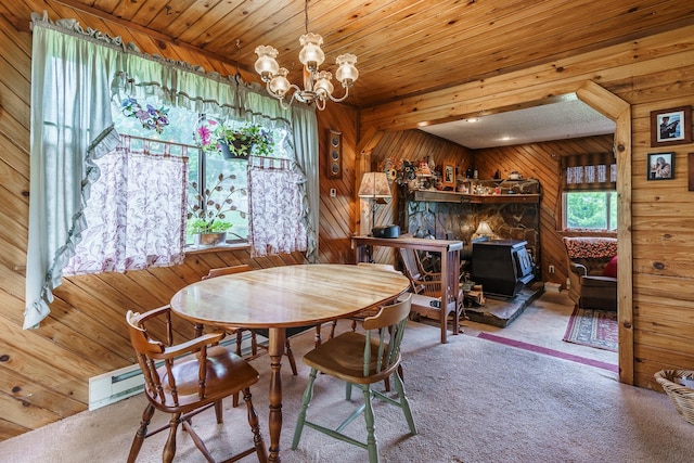 521 Clay St, Thompson Falls, MT 59873 - carpeted dining room featuring wood walls, a chandelier, and a wood stove