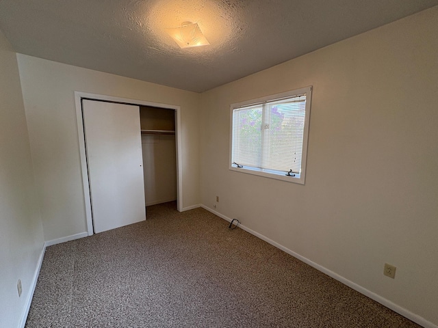 330 N Walnut St, Dillon, MT 59725 - unfurnished bedroom featuring carpet flooring, a closet, a textured ceiling, and baseboards